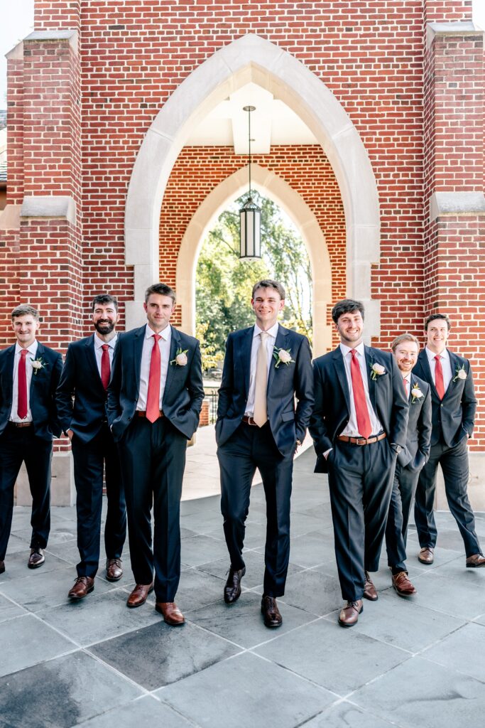 A group of groomsmen walk together toward the camera
