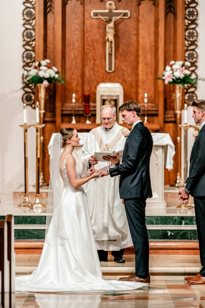 A bride and groom exchange rings during their St Bridget wedding