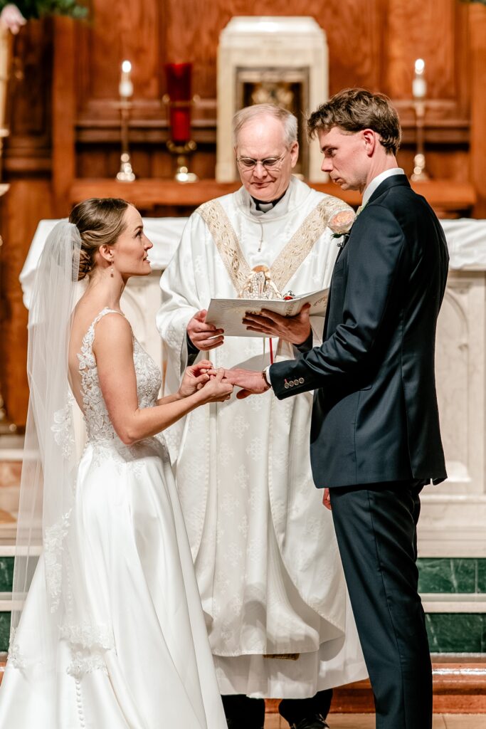 A bride and groom exchange rings during their The Estate at Independence wedding day