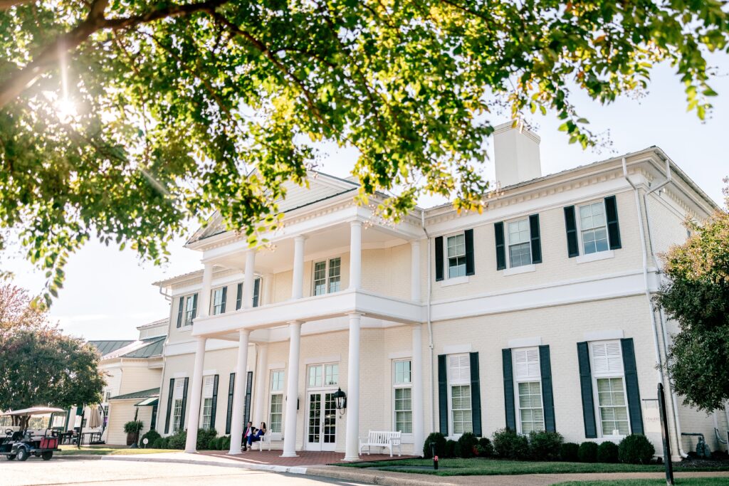 A historic manor framed by green trees