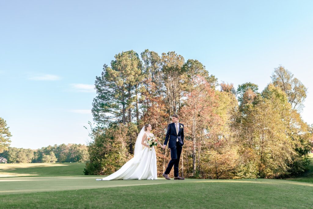 Bride and groom portraits walking along a golf course
