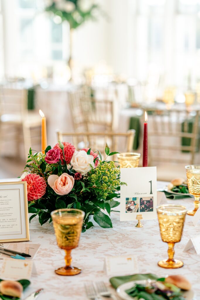 Table centerpieces for a wedding reception featuring table numbers with photos of the bride and groom as kids