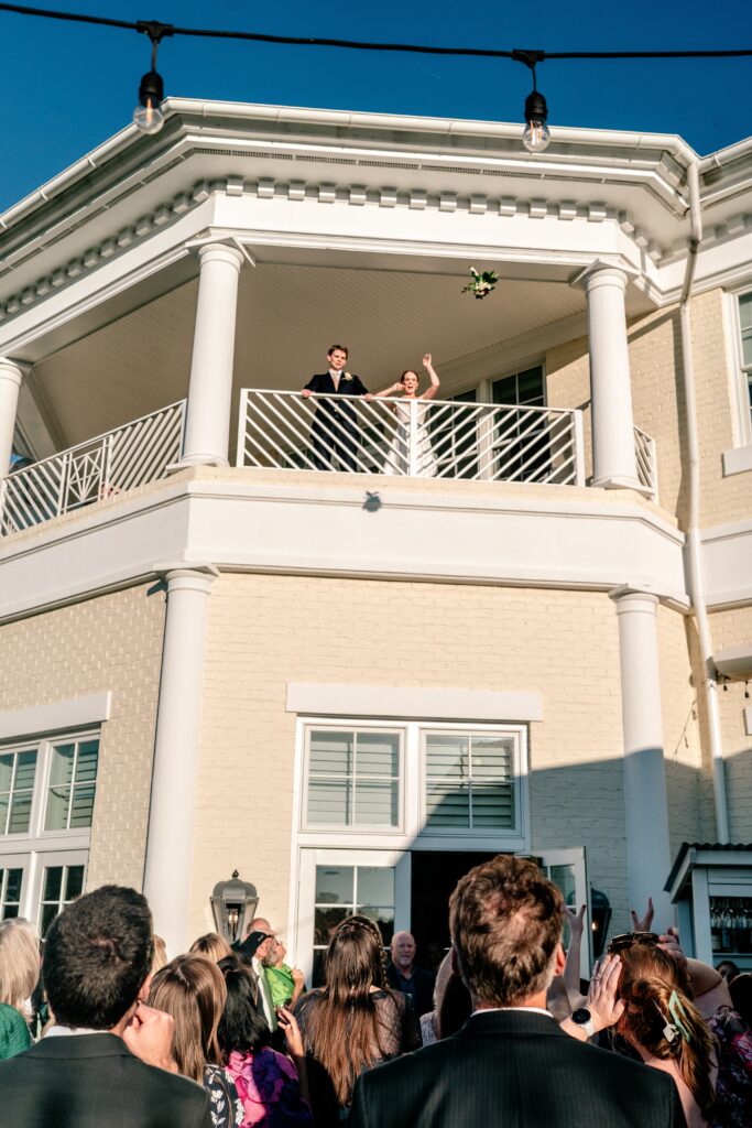 A bride tosses her bouquet toward the Richmond wedding photographer