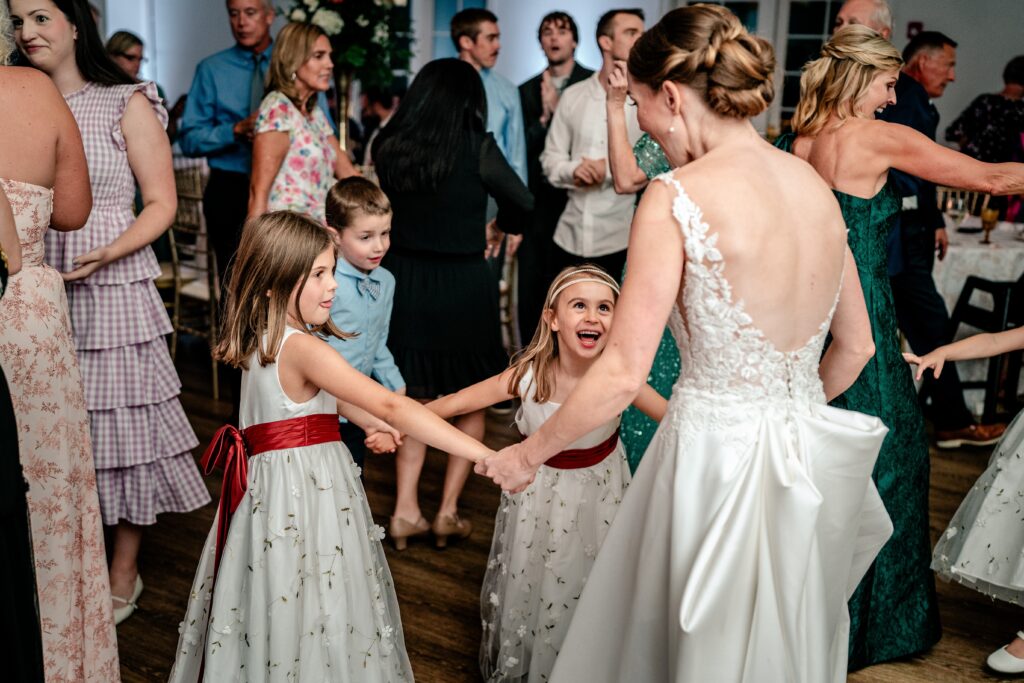 A bride and flower girls dancing together