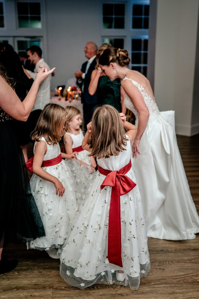 A bride and her flower girls gathered together on the dance floor in front of her Richmond wedding photographer