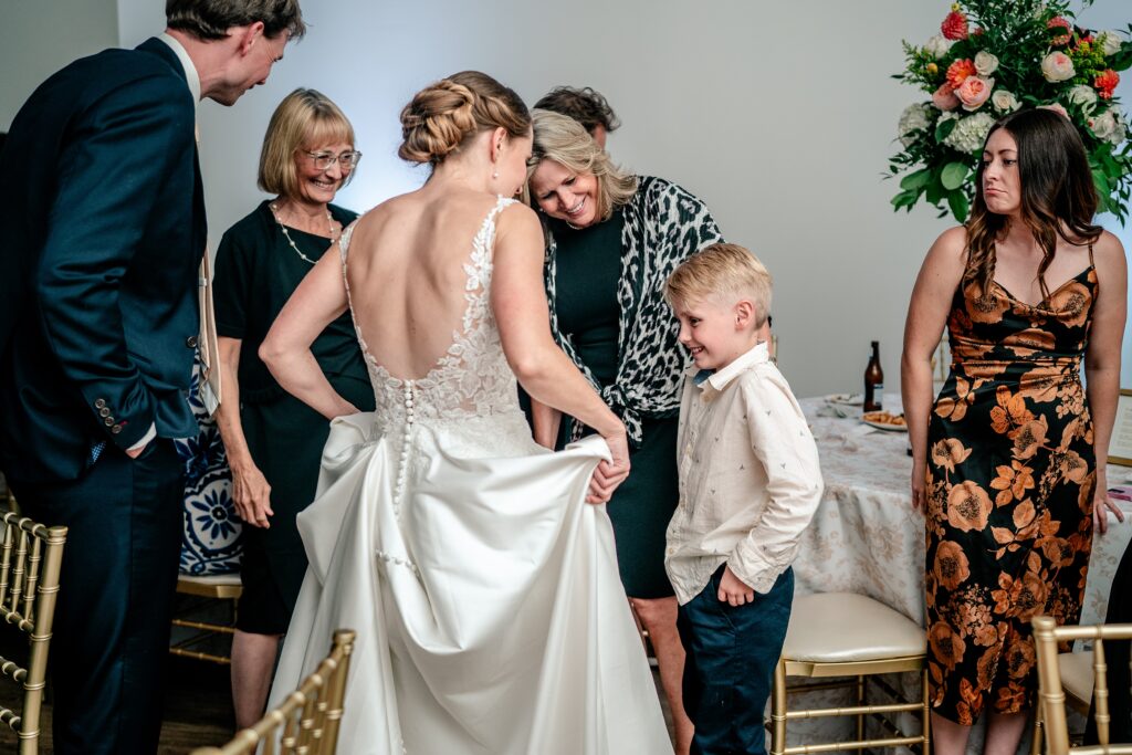 A little boy admires the bride's dress