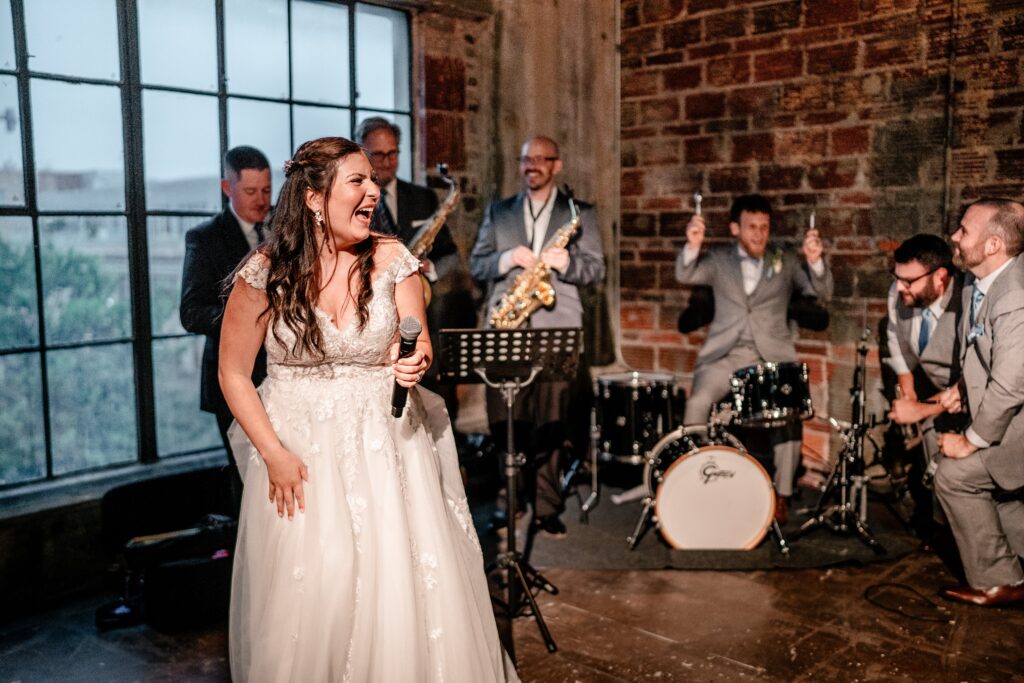 A bride and groom performing at their own wedding reception in front of their Washington DC wedding photographer