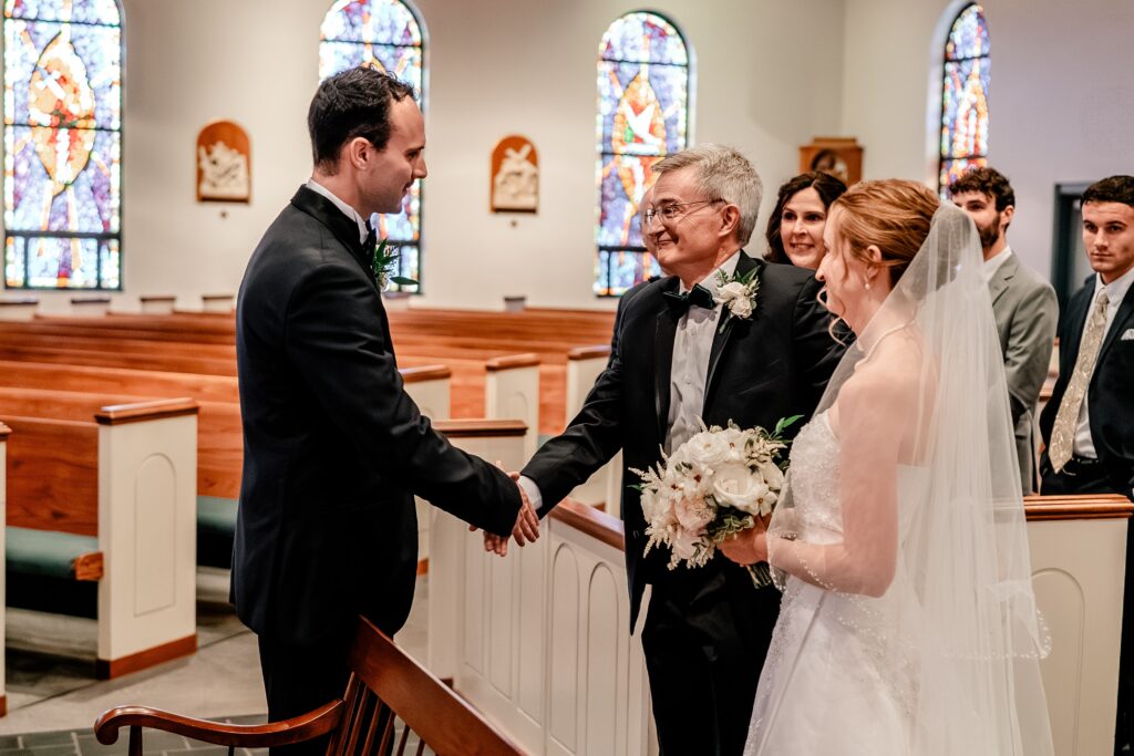 A groom shaking hands with the bride's father at the start of their Winchester VA wedding