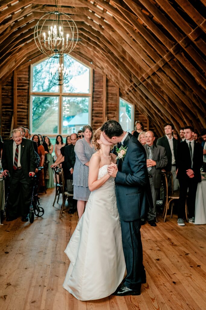 A bride and groom share a kiss at the end of their first dance
