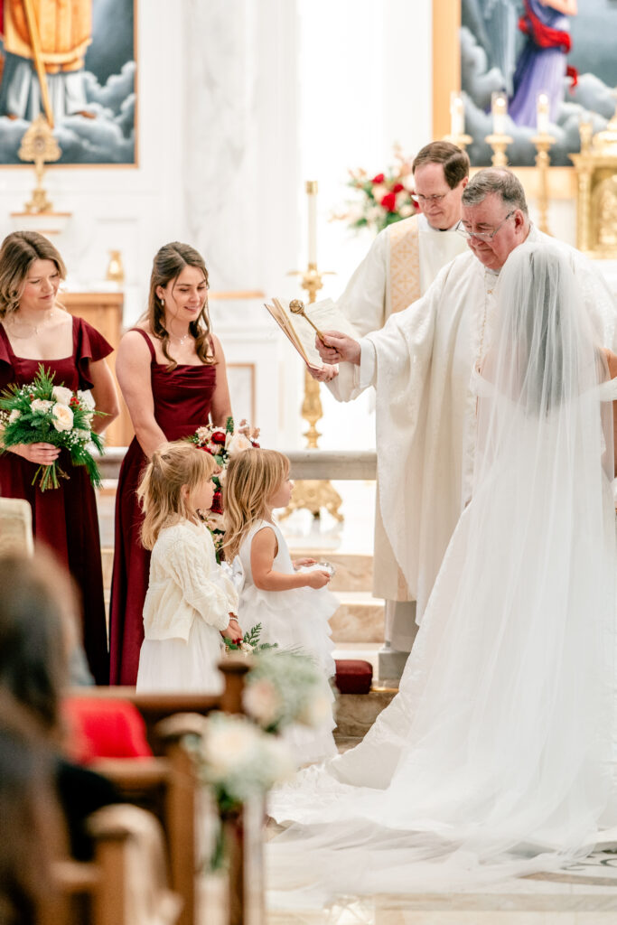 Flower girls holding the rings during a Catholic wedding in Purcellville