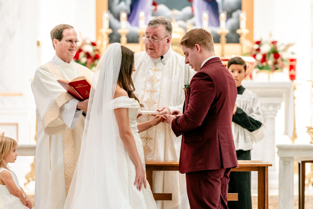 The bride and groom exchanging rings during their St Francis de Sales wedding in Purcellville