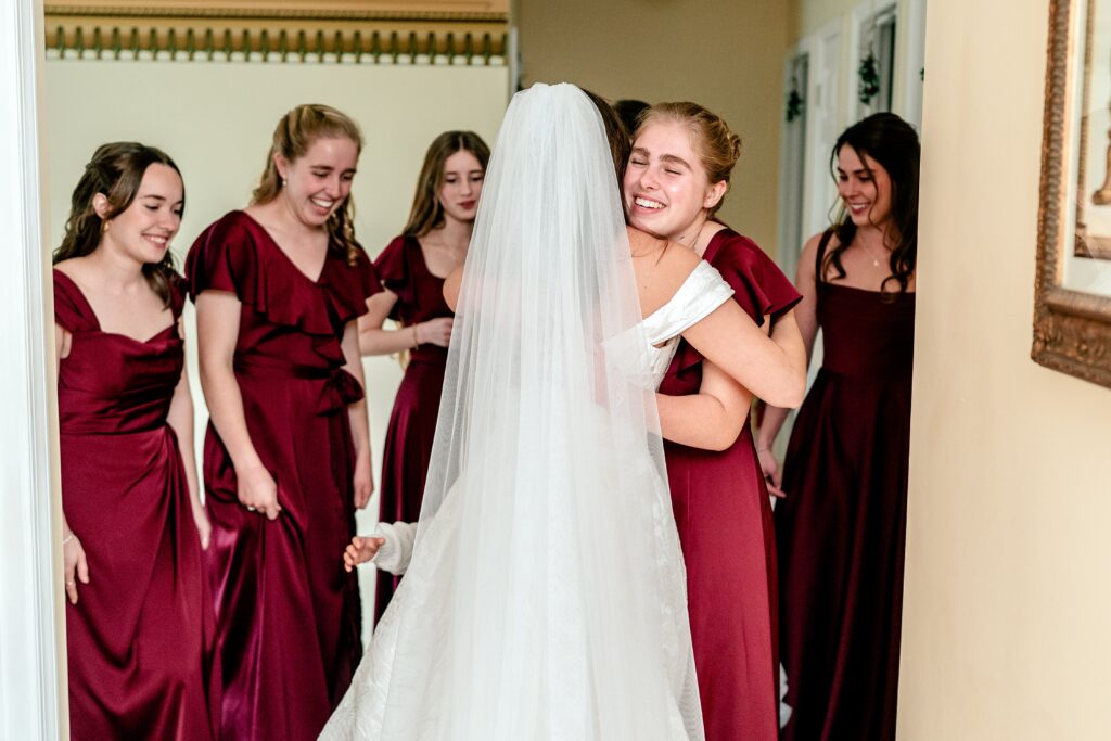 A bridesmaid hugging the bride on her wedding day