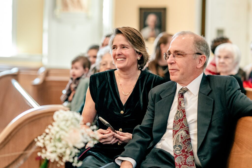 Parents of the groom beaming at the start of the wedding ceremony at St. Francis de Sales