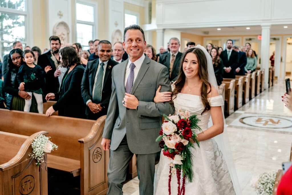A bride and her dad walking down the aisle for a Catholic wedding in Purcellville