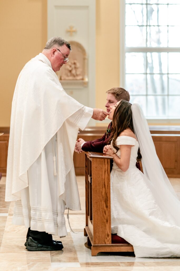A bride and groom receiving communion during their Catholic wedding in Purcellville