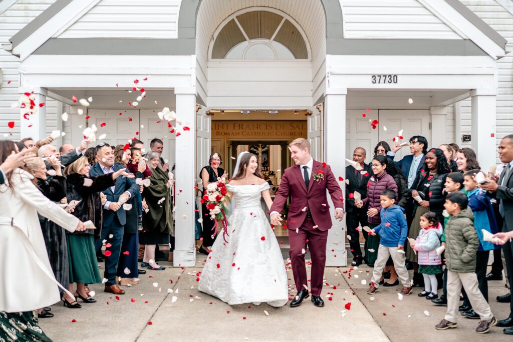 A flower petal sendoff outside of the church for a St Francis de Sales wedding in Purcellville