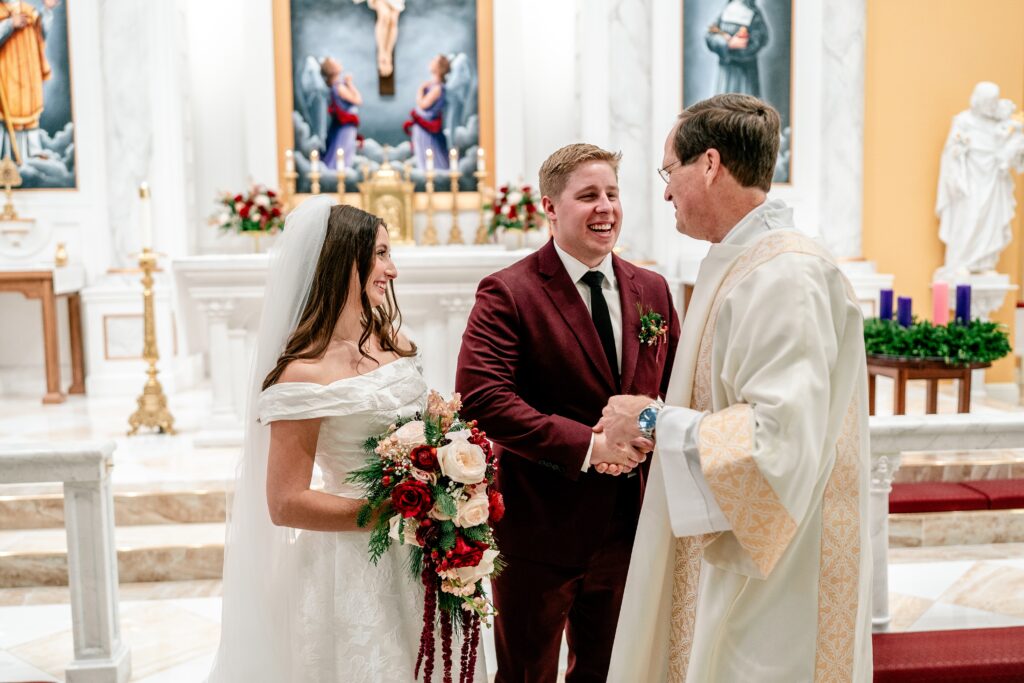 A bride and groom greeting the priest after their St Francis de Sales wedding in Purcellville