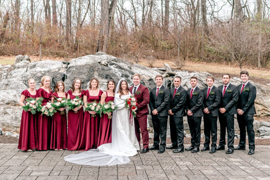 A wedding party posed for a classic portrait in front of the waterfall during a Historic Rosemont wedding