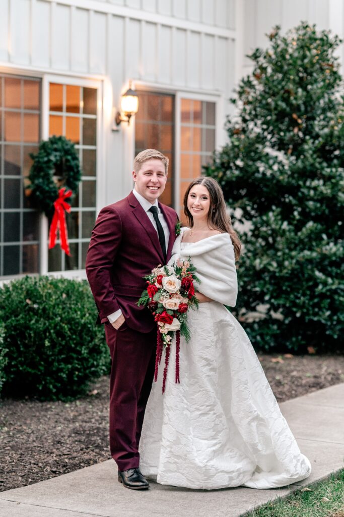 A traditional portrait of the bride and groom standing outside the barn for their Historic Rosemont wedding