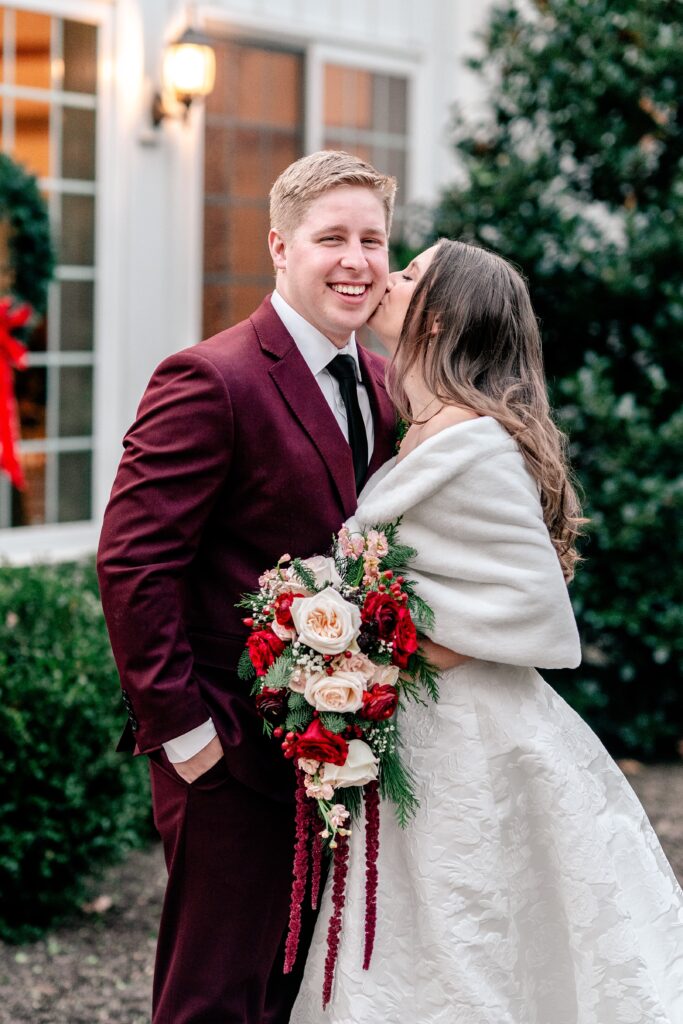 A bride kissing her groom on the cheek after a St Francis de Sales wedding in Purcellville