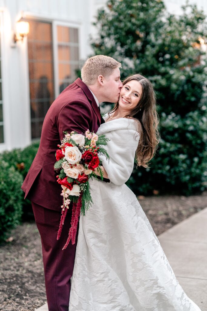 A groom kissing his bride on the cheek