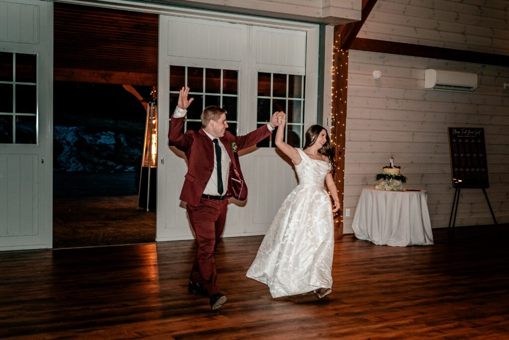 A bride and groom cheering as they enter their barn reception in Loudoun County