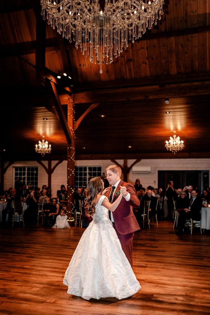 A bride and groom share their first dance under the chandelier for their Historic Rosemont wedding