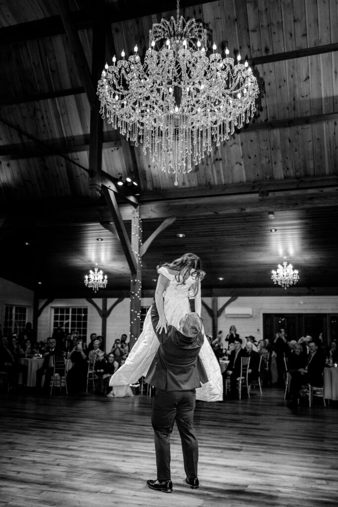 A groom lifting his bride as part of their choreographed first dance after their St Francis de Sales wedding in Purcellville