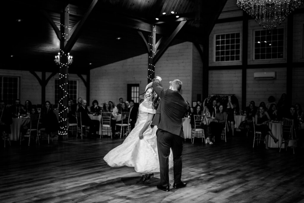 A groom twirls his bride during their first dance at their Historic Rosemont wedding