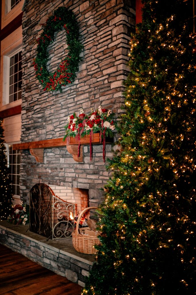 A Christmas wedding at Historic Rosemont Springs Barn with flowers on the mantle of the fireplace and a Christmas tree