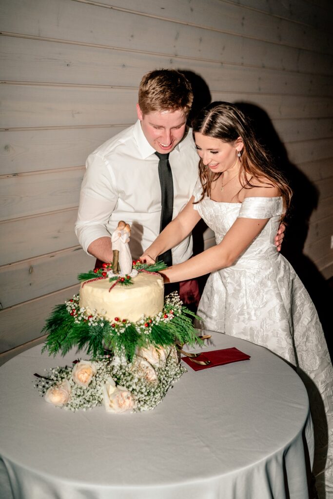 A bride and groom cutting the homemade wedding cake after their St Francis de Sales wedding in Purcellville