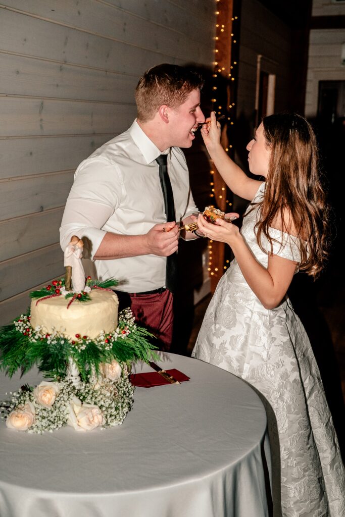 A bride and groom feeding each other cake in the Historic Rosemont Springs Barn