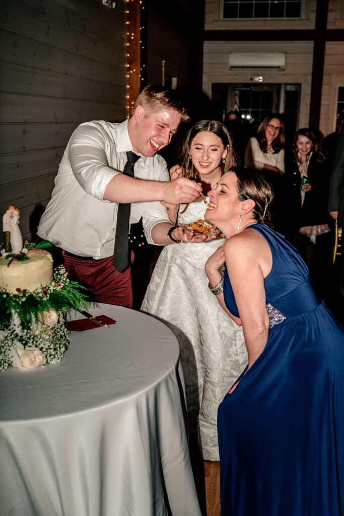 The groom feeding cake to his mother in law