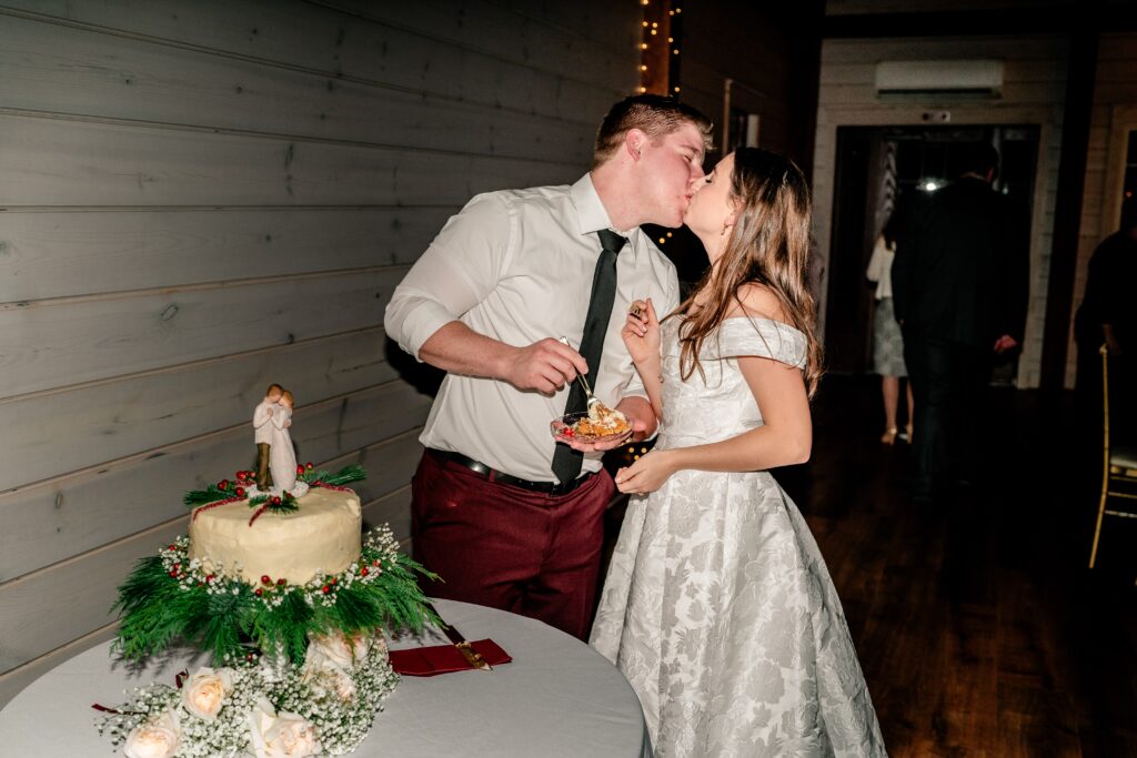 A bride and groom kiss after cutting the cake for their Historic Rosemont wedding