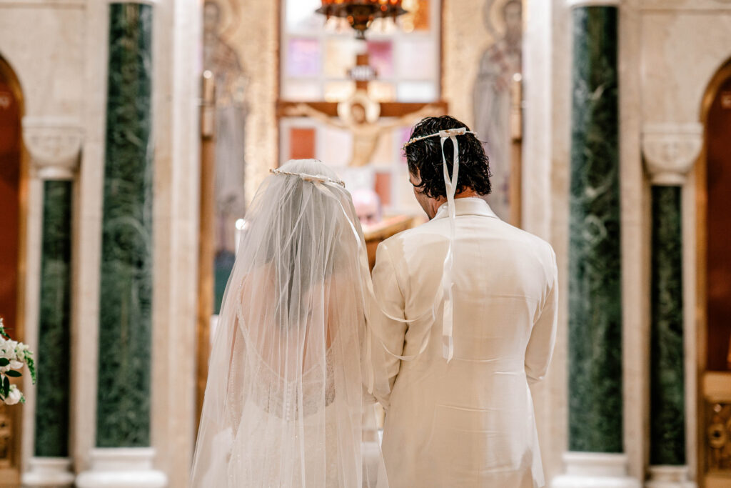 The bride and groom standing together with their crowns on from their St. Sophia Greek Orthodox Church wedding