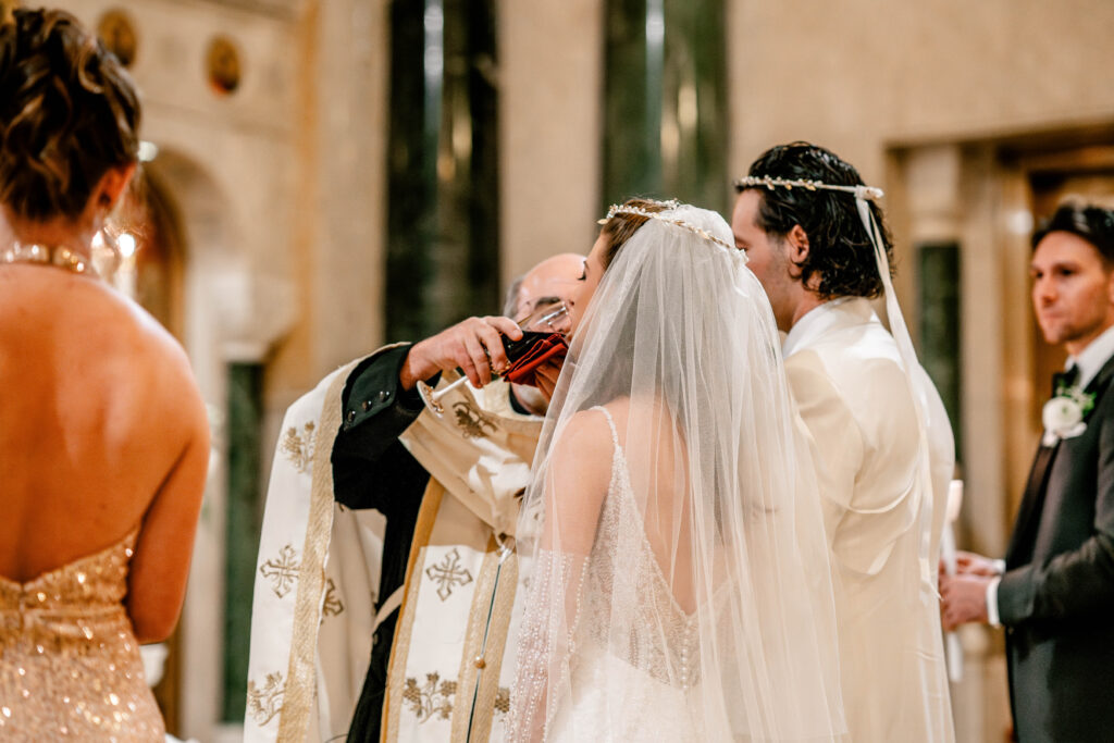 The bride drinking from the common cup during her Greek Orthodox wedding in DC