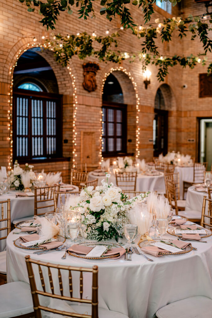 White floral centerpieces and pink accents on tables at St. Francis Hall