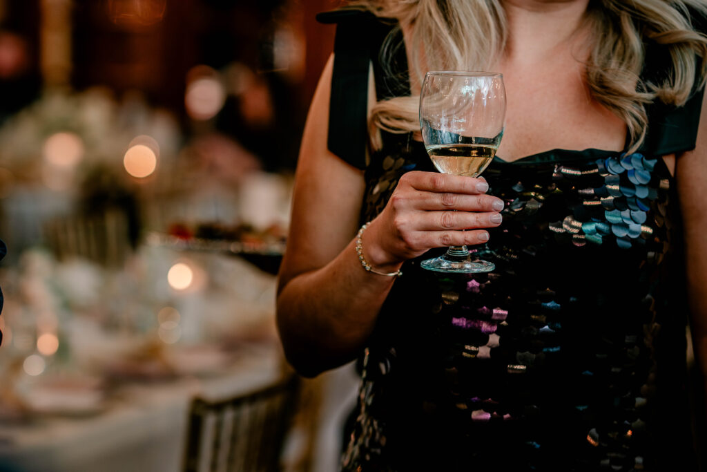 A guest holding a glass of white wine