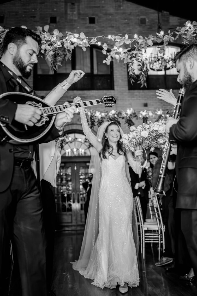 A bride cheering as she enters her St. Francis Hall wedding reception