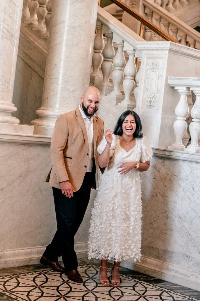 A couple laughing together in an alcove during their Library of Congress engagement photos