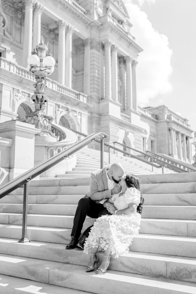 A couple sharing a kiss on marble steps during their Washington DC engagement photos