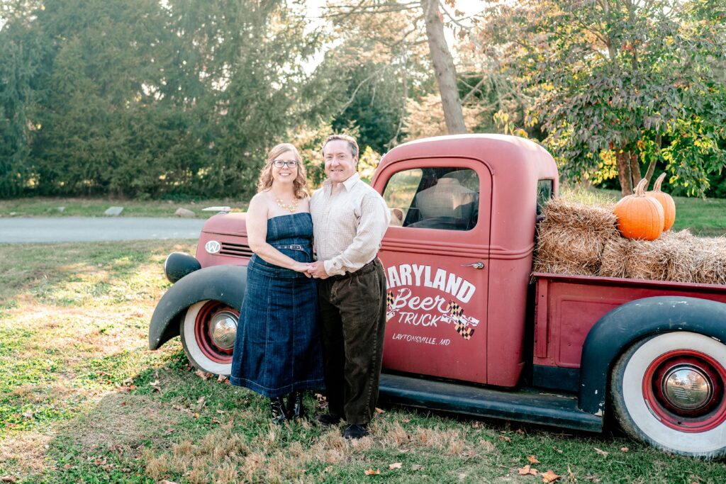 A couple posing in front of an old truck for their Maryland engagement photos