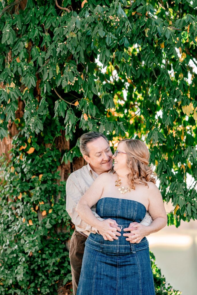 A man and woman smiling at each other during brewery engagement photos