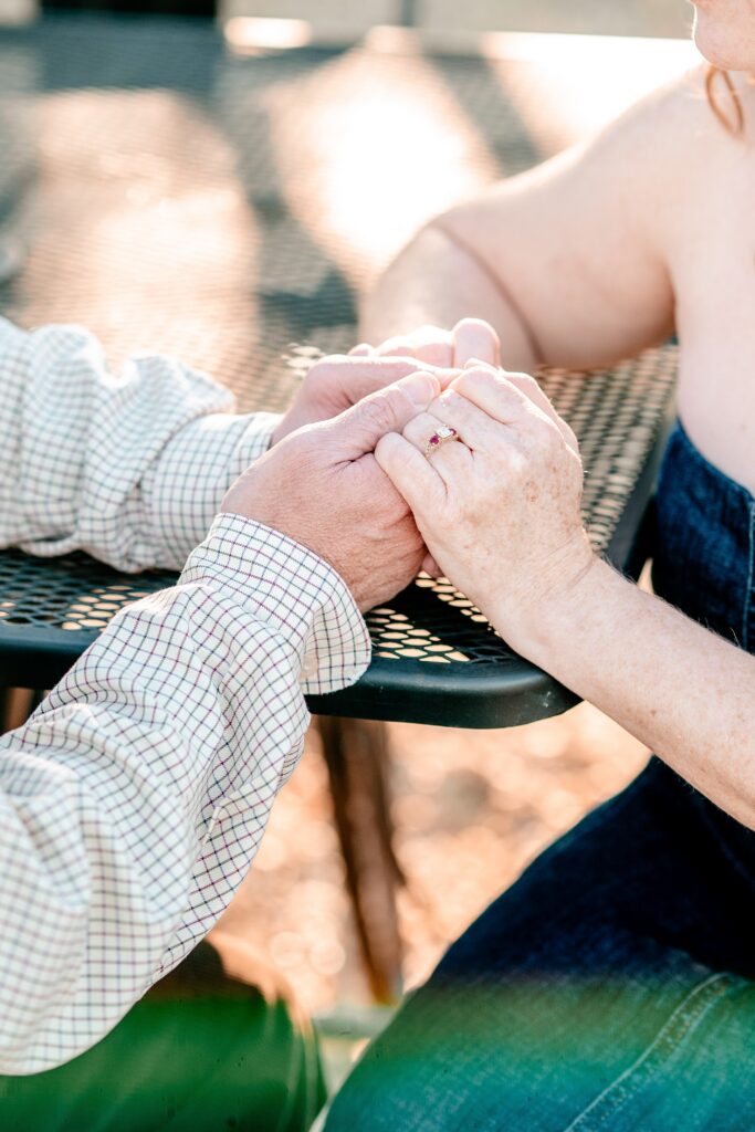 A couple holding hands showing her ruby and diamond ring