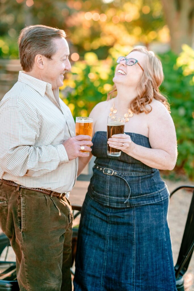 A couple laughing together as they enjoy beers on the patio at Waredeca Brewing Company
