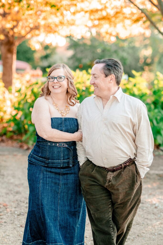 A woman smiles at the camera as her groom to be smiles at her