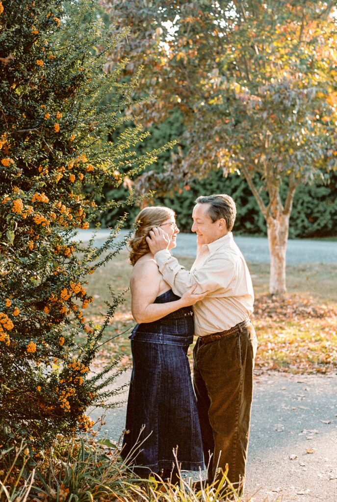 A man tucks hair behind the ear of his bride to be in golden hour light for their Maryland wedding photographer