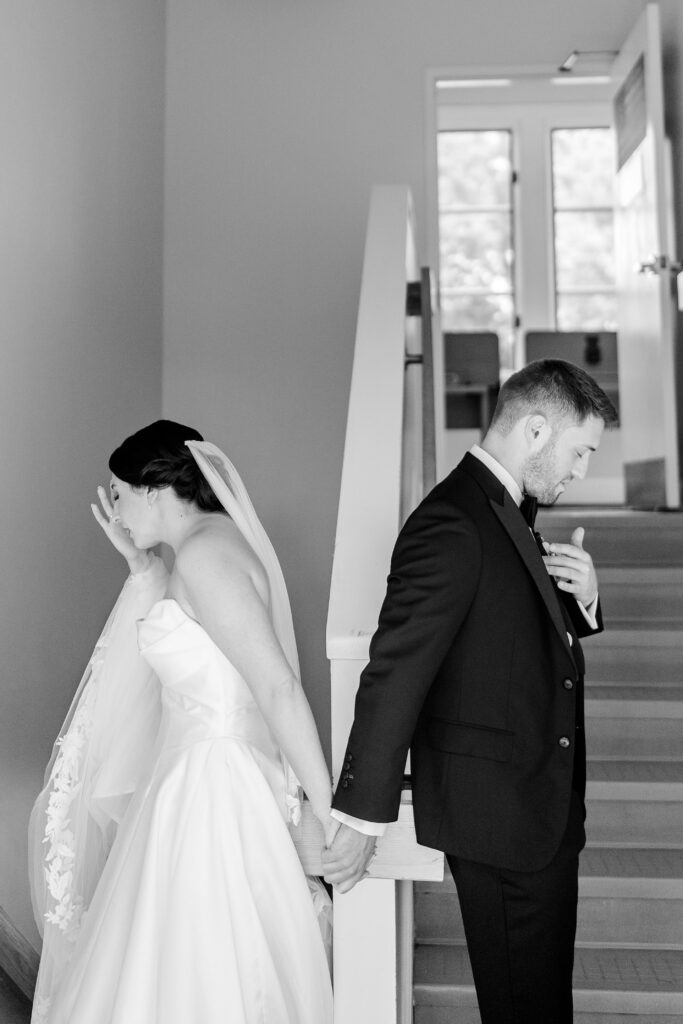 A bride and groom sharing a first touch in the stairwell before their St. Francis de Sales wedding