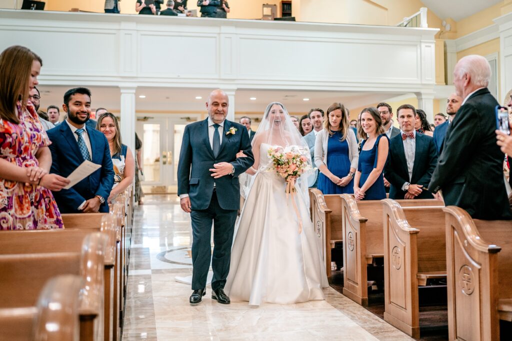 A bride walking down the aisle with a grin on her face before her Shadow Creek wedding reception