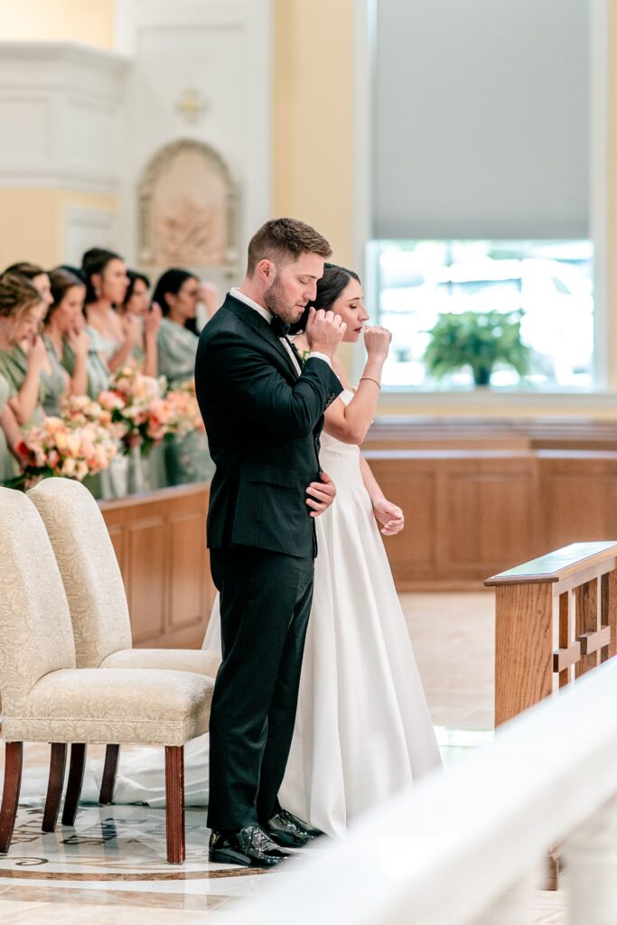 A bride and groom preparing to listen to the Gospel reading of their Catholic wedding ceremony